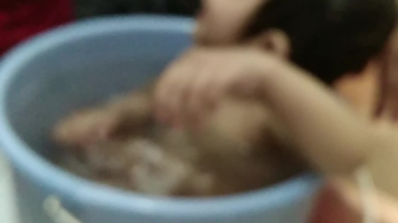 cute baby taking bath in bucket