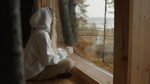 Woman in a Hoodie Watching Through the Window