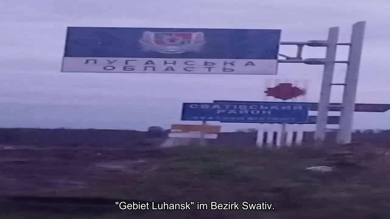 Eine Gruppe ukrainischer Soldaten hält den Moment fest, als sie sich der Stele "Oblast Lugansk" im