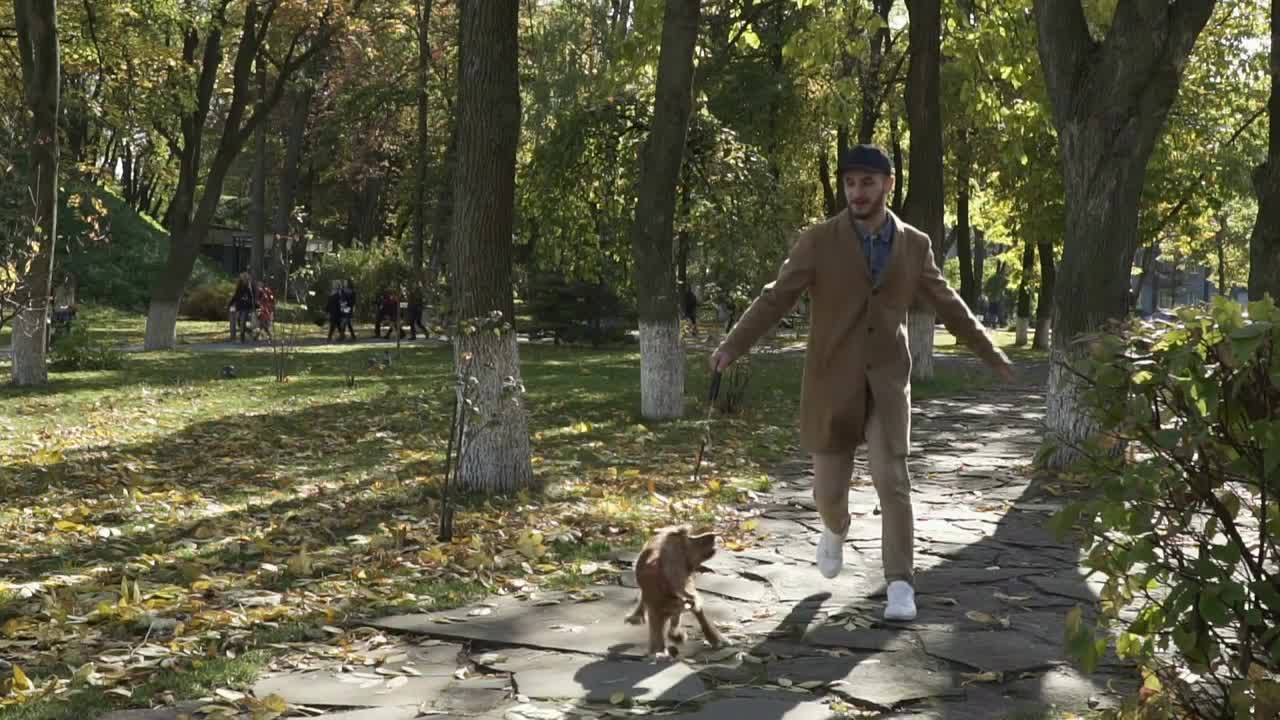 Young guy runs with dog in slowmotion in park