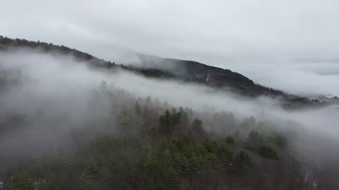 The clouds covered the mountains with a thin layer of clothing.