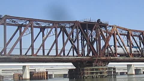 Two Amtrak trains meet on a bridge.