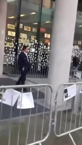 BBC news studio windows being plastered with stickers, posters, and pictures