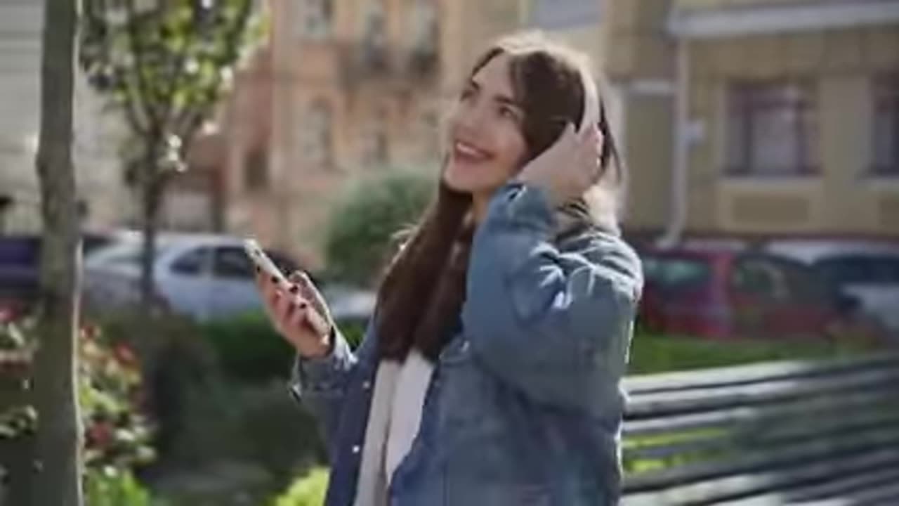 A girl singing a song on her mobile and feeling happy and enjoying music