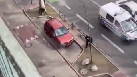 Woman breaks a police car's window