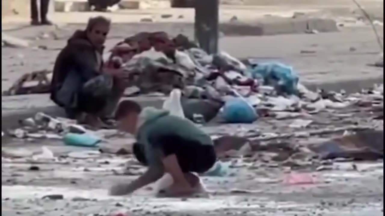 A group of children collecting flour from the ground in Gaza to make bread