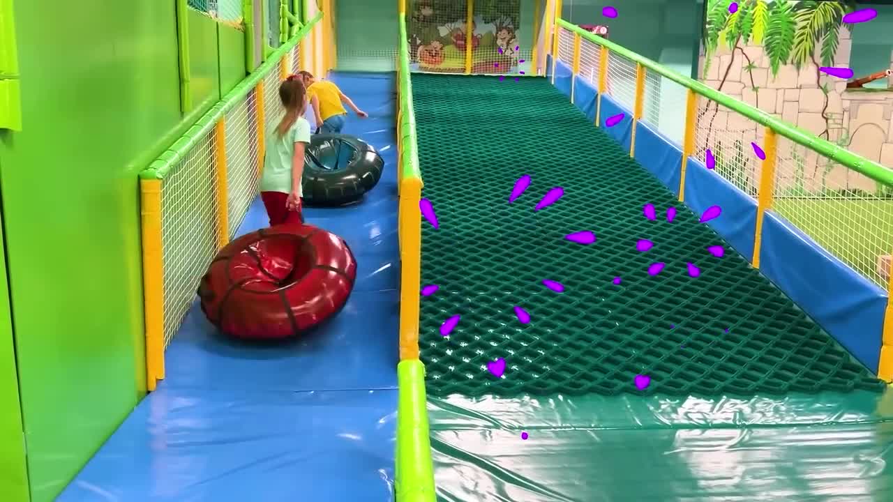 Sofia and a lot of colored balls on the Playground for kids