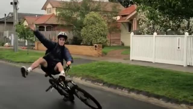 Guy Ride on Bicycle Without Using Hands With Legs on Handle bars Falls to the Ground