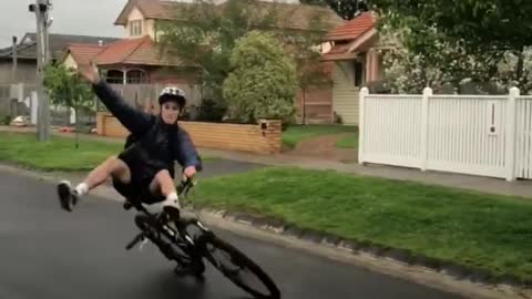 Guy Ride on Bicycle Without Using Hands With Legs on Handle bars Falls to the Ground