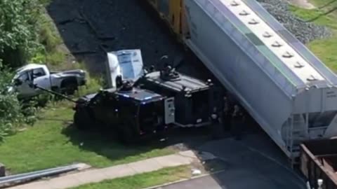 A high speed police pursuit where the armed suspect drives directly into a passing freight train