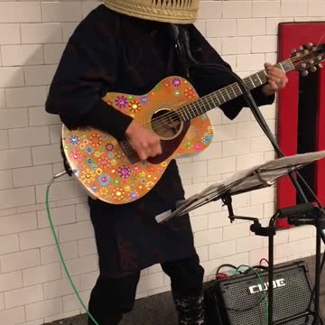 Basket head man plays glitter guitar on subway