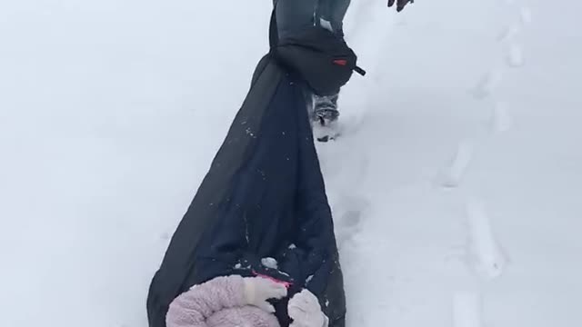 Daddy pulling Alex in the snow!