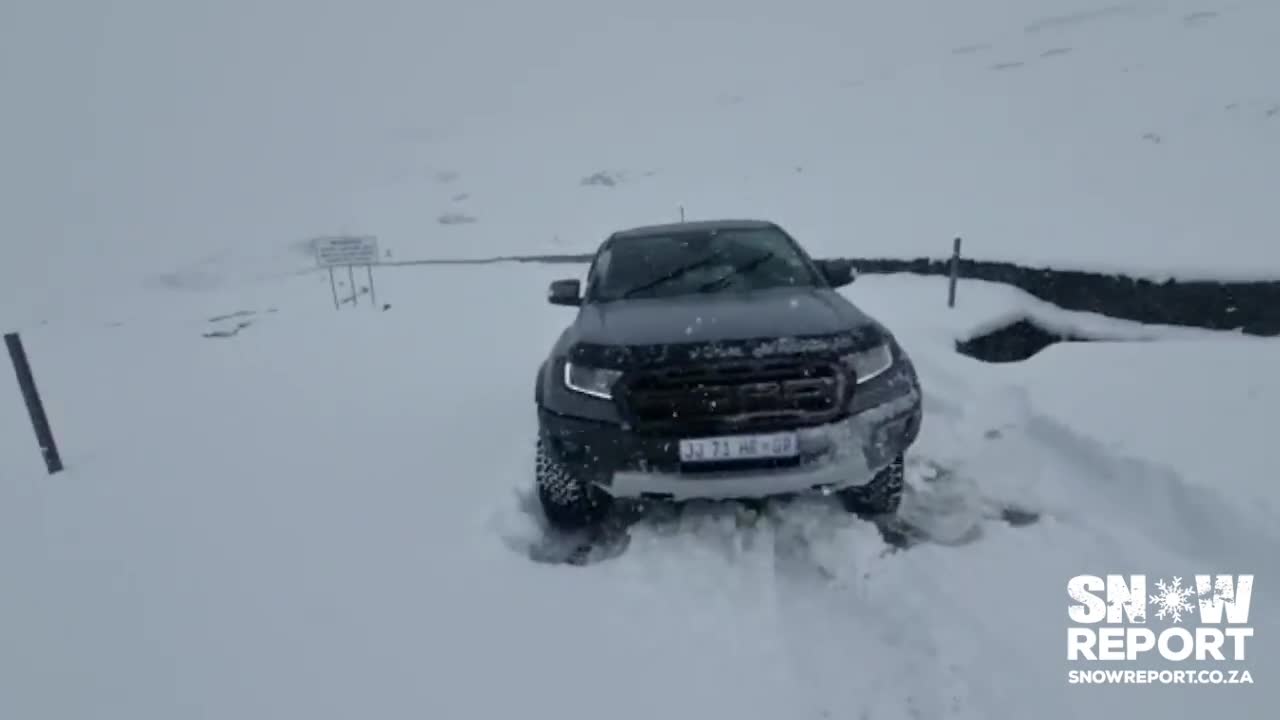 Vehicles struggle to navigate through snow on Sani Pass