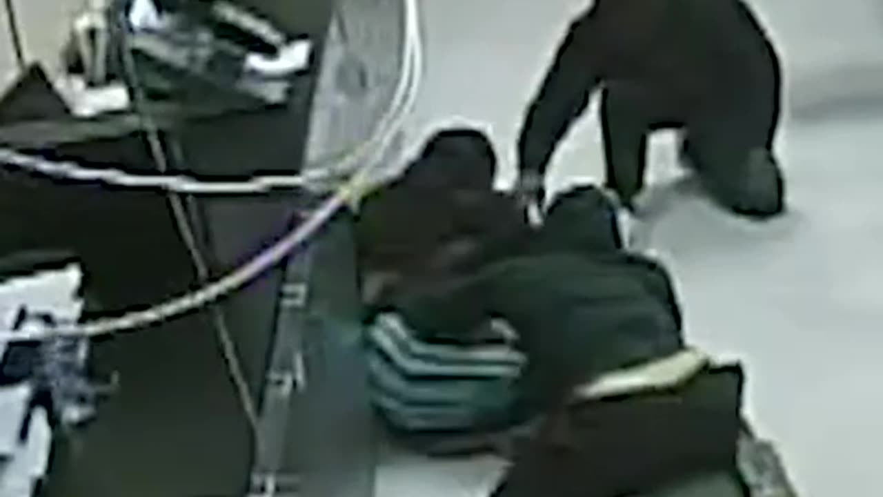 Security footage captured two masked men breaking through the ceiling of a check-cashing