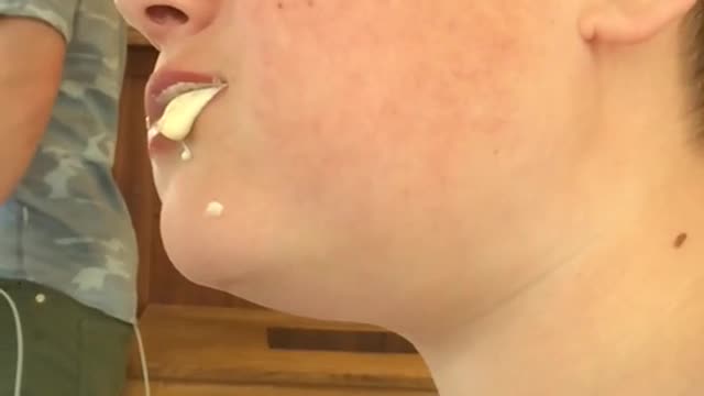 Kid chews white pudding in slowmotion