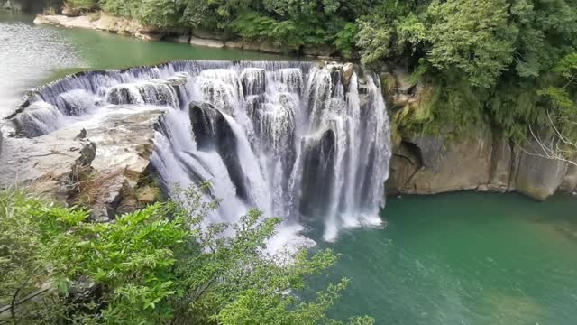 waterfalls cascading through multi layer of rocks formation