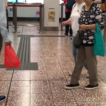 Boy in red yells at phone in subway station