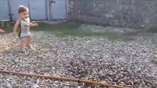 baby plays and runs away from water