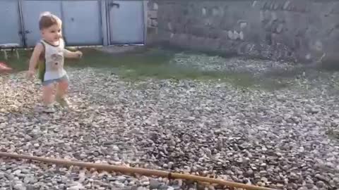 baby plays and runs away from water