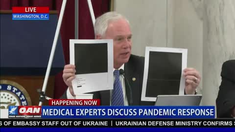 Senator Johnson holds up redacted documents
