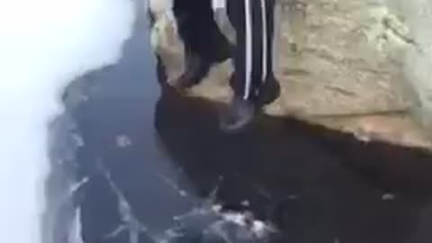 Guy jumps from rock to ice and falls