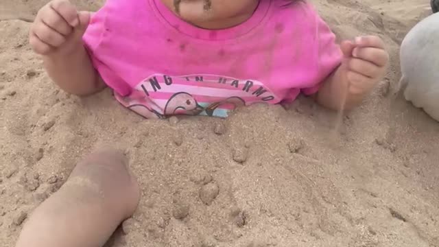 Little girl playing in the sand and having fun