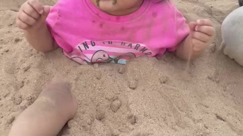 Little girl playing in the sand and having fun