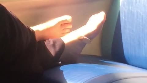 Bare feet on seat on train