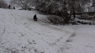 Guy black clothes snow hill sled slide fail