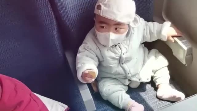 Intelligent kid-baby removing the mask and putting it back again.