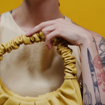 A Woman Posing with a Yellow Handbag