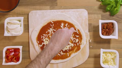 Top View Male Sprinkles Grated Cheese on Pizza