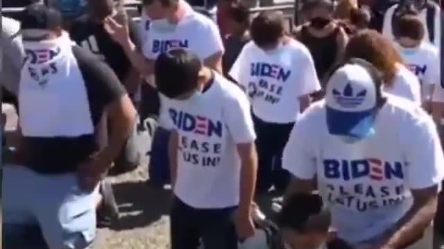 Migrants Kneel At Port Of Entry In Like-New 'Biden Please Let Us In!' T-Shirts