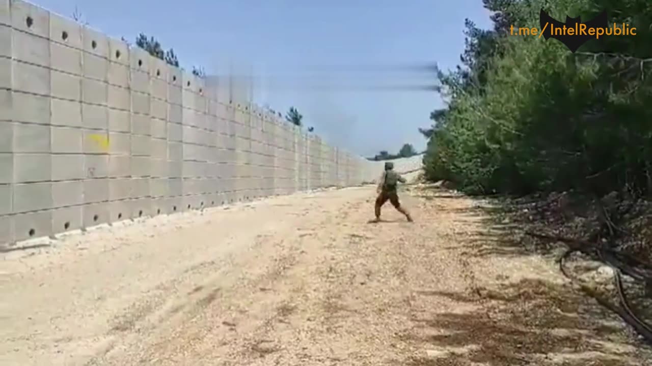 Isreali soldiers throws flaming munition over wall