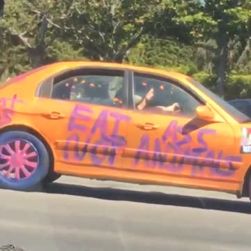 Orange car has purple writing on it