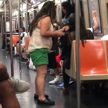 Girl brushing other girls hair on subway