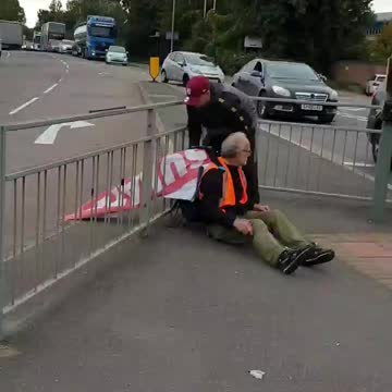 Leftists blocking roads again today get tied to the railings with their own banner 😂