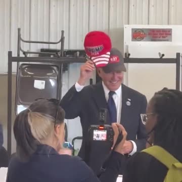BIDEN PUTS ON TRUMP HAT