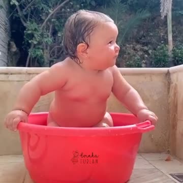 a child is playing with water very beautiful moment