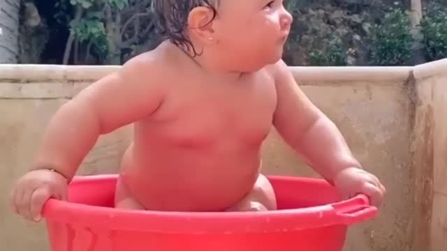 a child is playing with water very beautiful moment