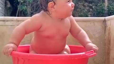 a child is playing with water very beautiful moment