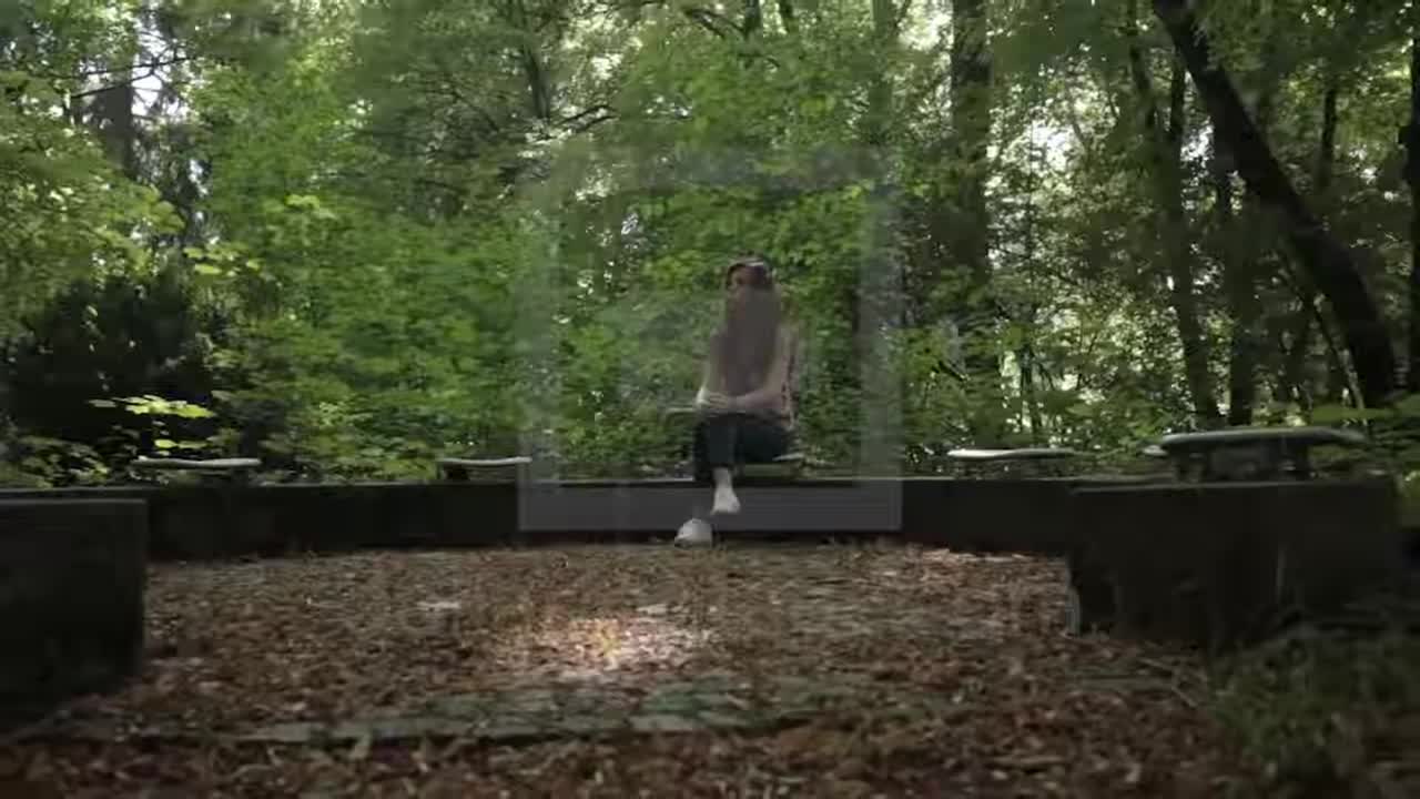 Girl sitting alone in forest with circle of seats