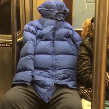 Person subway blue puffy jacket tied holes covered