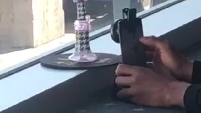 Guy trying to take picture of purple dotted bong airport airplane