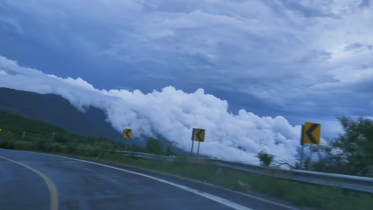 going down a curved highway through a mountain range