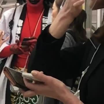 Man face painted red and curly wig on subway