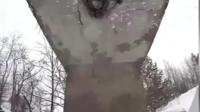 Man defies gravity snowboarding underside of bridge