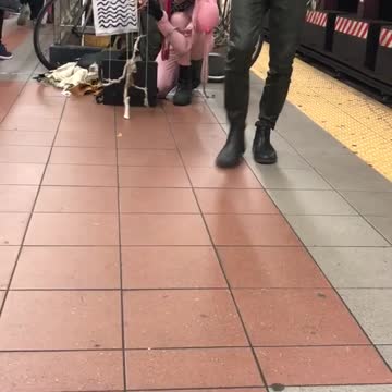 Person dressed in pink costume playing with puppet