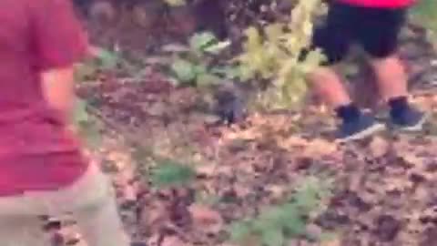 Red shorts hoodie kid falls down hill in woods