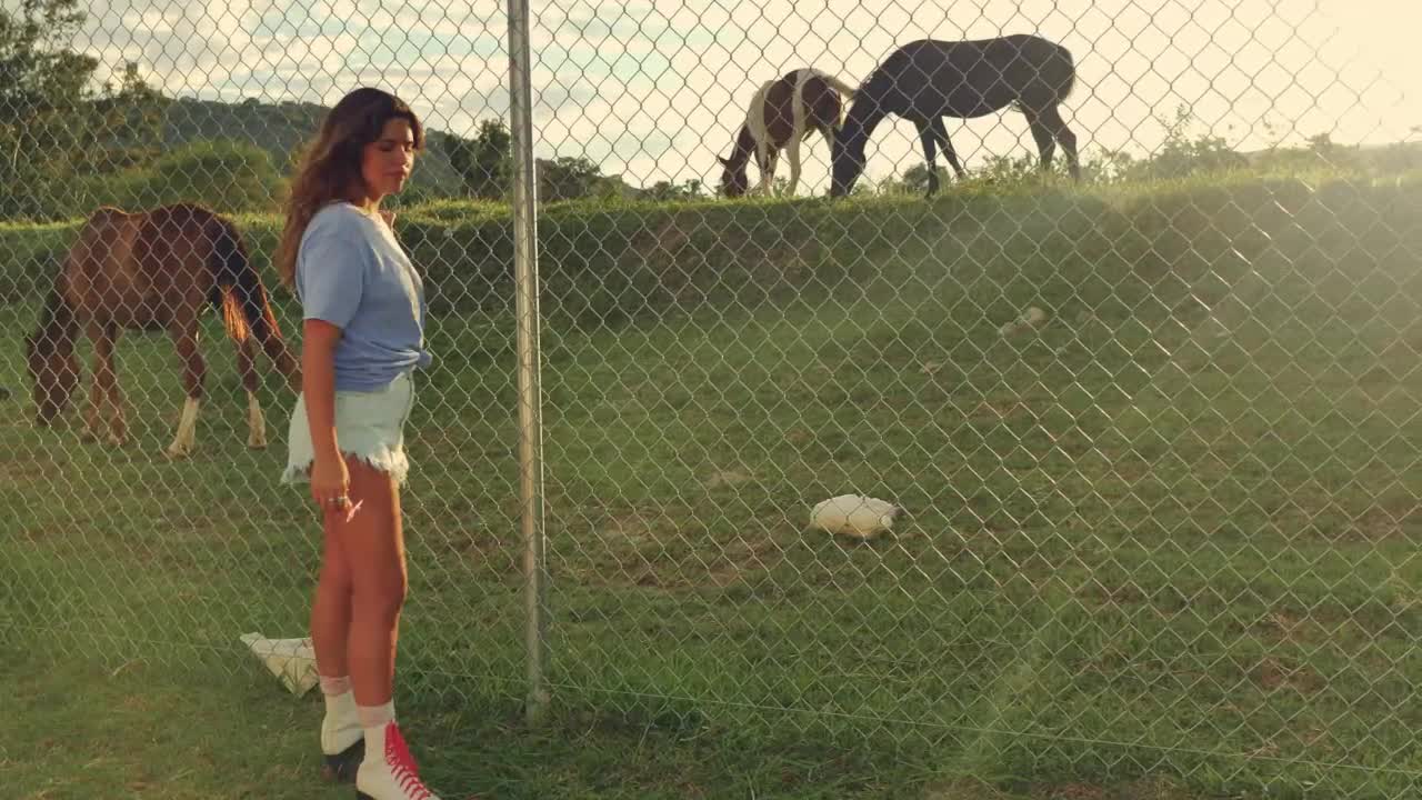 Young woman appreciating horses during a ride with roller skates